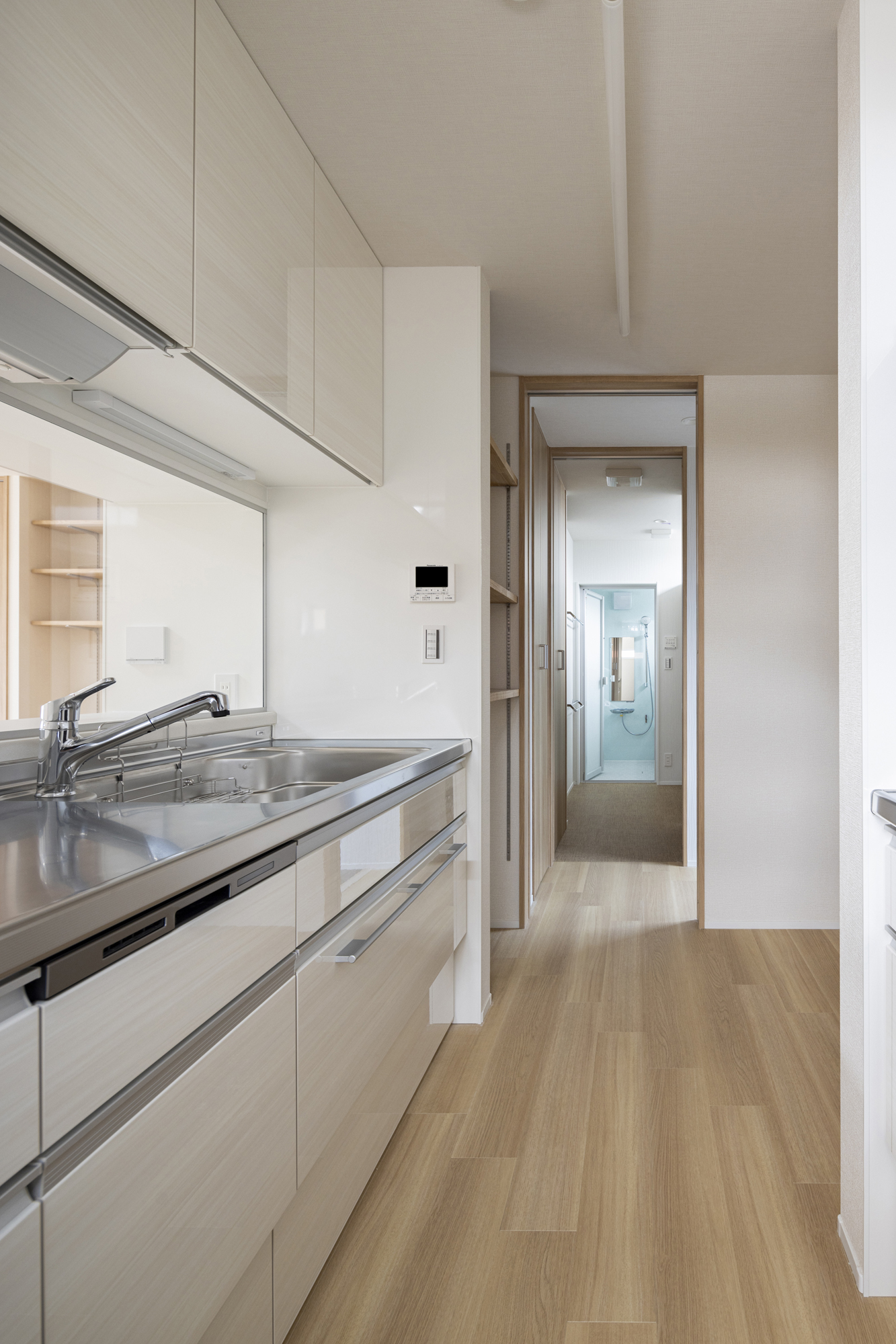 二型キッチンの奥にはパントリーとバスルームがあり、家事動線がシンプル
