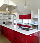 木と漆喰の空間に真っ赤なオープンキッチンが映えます。