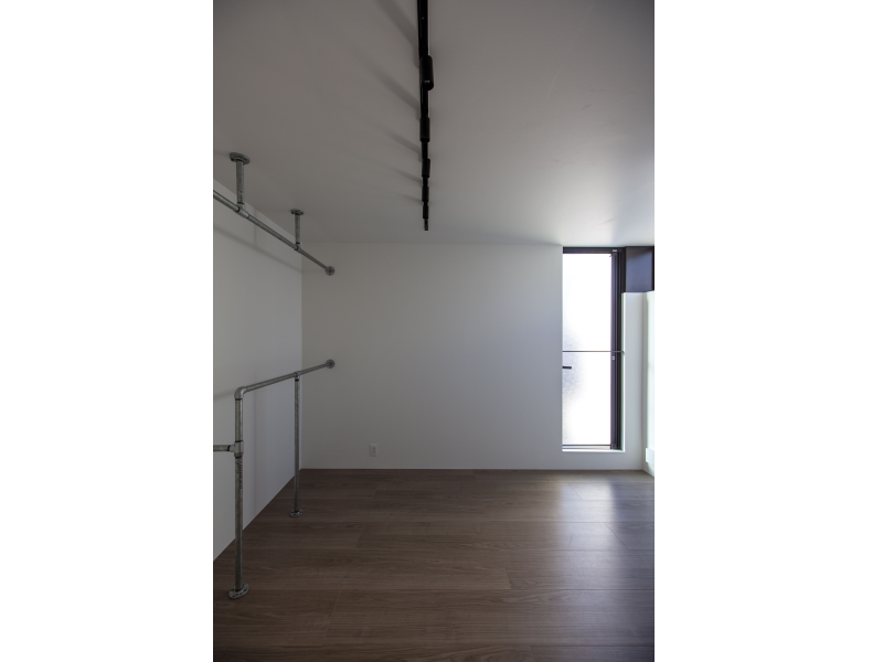 白ガス管をハンガーパイプに利用した寝室