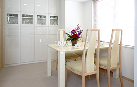 光沢のある素材の白い食器棚。ガラス扉の所にはお気に入りの食器を飾って。