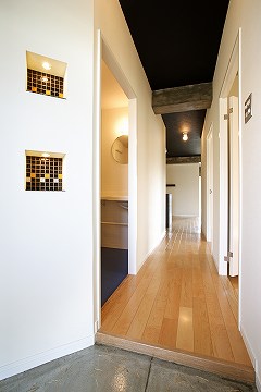 壁と天井のクロスは同じレリーフ加工の色違い。ニッチの照明が玄関の印象を明るく