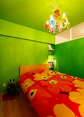 壁のグリーン色が表情をひきしめる寝室