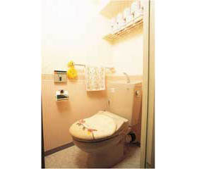 ピンクで愛らしくまとめたトイレ。ペーパーホルダーとタオル掛けはゴールド