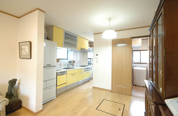 木目が綺麗なフローリングと、黄色を基調としたキッチンのデザインがマッチ