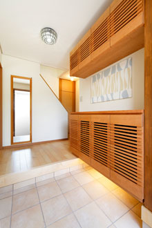 玄関収納は風通しの良い格子のデザインに。材にはブラックチェリーを使用して造作。
