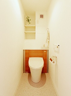 広々とした清潔感のあるトイレに。トイレの位置を移動させたことでできた空間に棚も造
