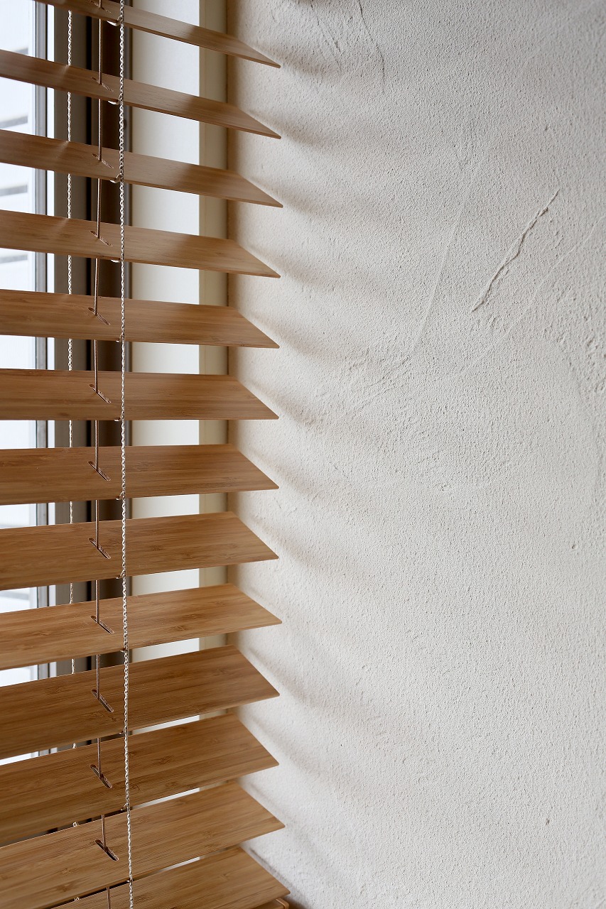 竹ブラインドを窓に使用した寝室