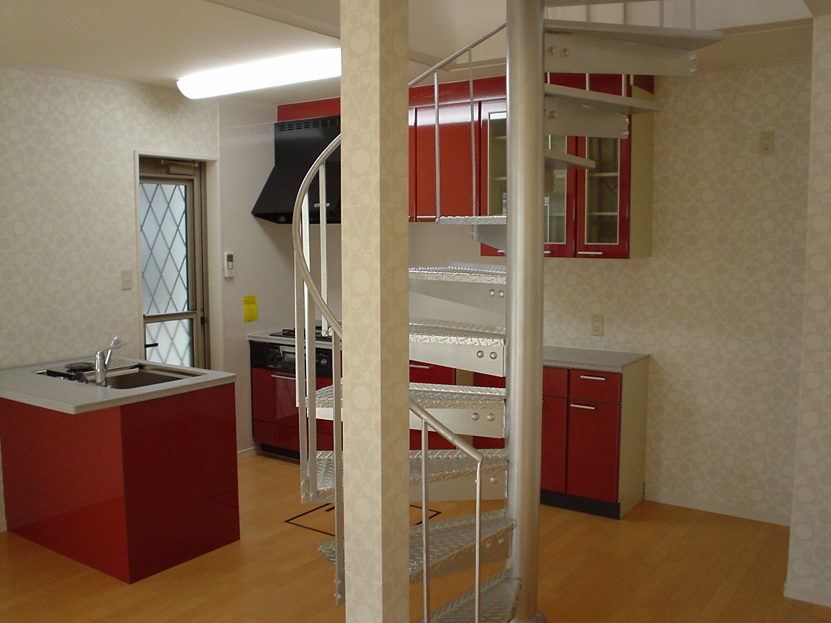 アイランドキッチンを原色カラー赤で、らせん階段はシルバー色に