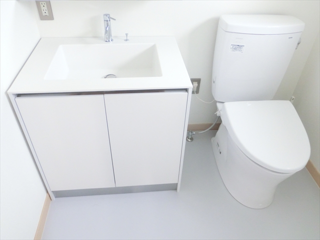 白で統一したシンプルな洗面化粧台とトイレ